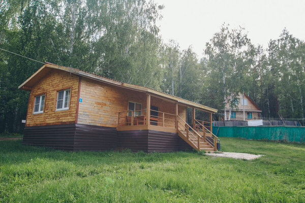 летний деревянный дом в березовой роще. кемпинг в лесу. туристическая база для отдыха путешественников. экологичное строительство