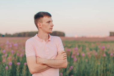 Bir adam çiçek çayırında yürüyor. Aşk ve bahar çiçek açıyor.