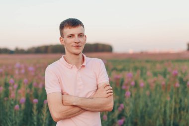 Bir adam çiçek çayırında yürüyor. Aşk ve bahar çiçek açıyor.