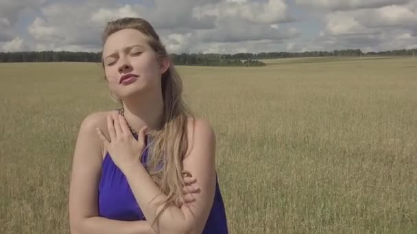 穿着蓝色衣服的女孩在田野里唱着悲伤的歌曲 在大自然中歌唱 在室外拍摄剪辑 面对特写 — 图库视频影像