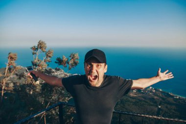 Adam aydınlığın kıyısında duruyor. Dağları aşın