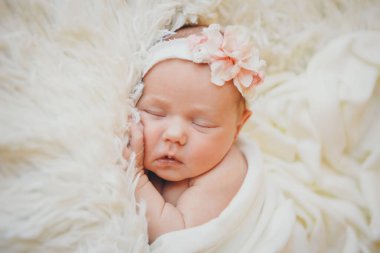 Yüzü sargılı, başında çiçekler olan bir çocuğun yüzü.