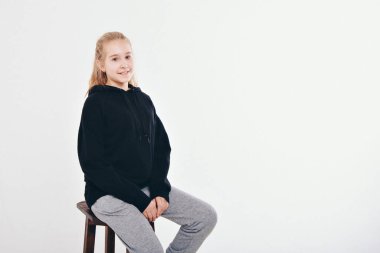 Kış geldi ama yürekten değil. Kapüşonlu mavi gözlü, sıcak ve narin sarışın kızın portresi kıkırdıyor ve kameraya bakıp gülüyor beyaz arka planda keyifli bir ruh hali var.