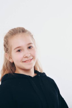 Kış geldi ama yürekten değil. Kapüşonlu mavi gözlü, sıcak ve narin sarışın kızın portresi kıkırdıyor ve kameraya bakıp gülüyor beyaz arka planda keyifli bir ruh hali var.