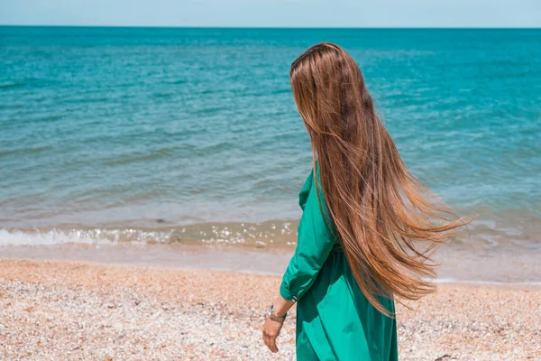 Een Meisje Met Lang Haar Een Groene Jurk Het Strand — Stockfoto