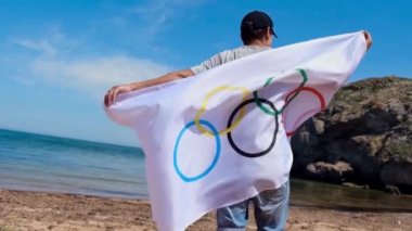 20.05.2021. Soçi. Tokyo 'da Yaz Olimpiyatları. Sahilde bayraklı bir adam