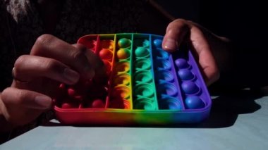 Modern bir pop it oyuncağı. Stres önleyici son moda oyuncaklar, çocukların elindeki basit gamzeler. Renkli baloncuklar patlıyor.