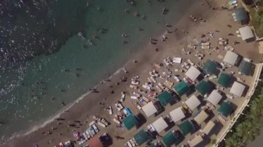 Dar bir kıyı şeridi olan deniz ve sahilde birçok tatilci. Bir İHA 'dan ateş etmek: Şehir plajı..