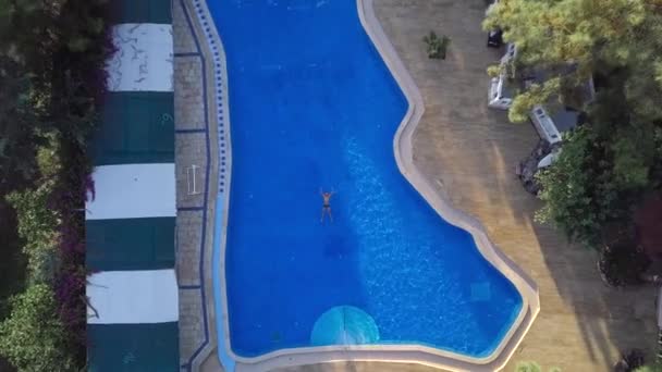 Uitzicht op de drone: een man die in de zee zwemt. Een zwemmer in het water. Top uitzicht op het zwembad van de hotels — Stockvideo