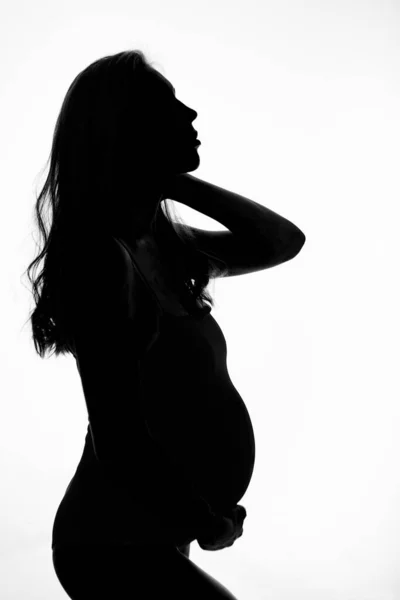 Silhouette di donna incinta su sfondo bianco — Foto Stock