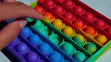 Modern bir pop it oyuncağı. Stres önleyici son moda oyuncaklar, çocukların elindeki basit gamzeler. Renkli baloncuklar patlıyor.