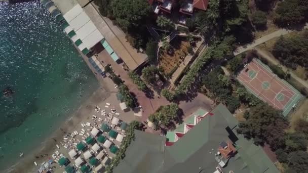 Laut dengan garis pantai yang sempit dan banyak liburan di pantai. shooting from a drone: a city beach. — Stok Video