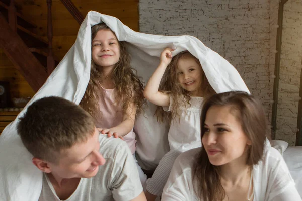 Ranní rodina: děti s rodiči, kteří si hrají v posteli. probouzí se ze snu. Právě jsem se probudil. láska — Stock fotografie