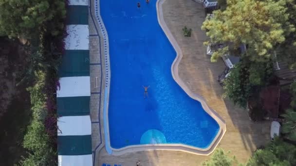 Vista drone: um homem nadando no mar. Um nadador na água. Vista superior da piscina dos hotéis — Vídeo de Stock