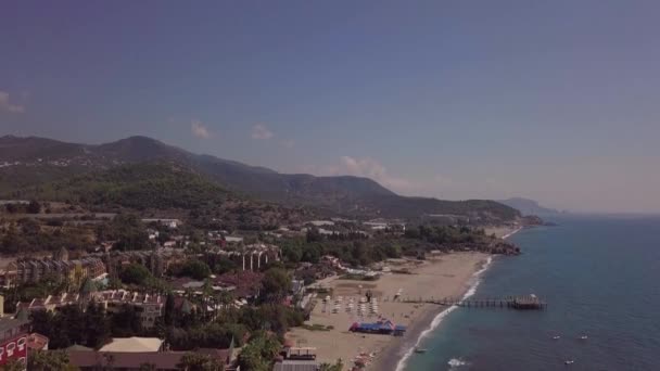 El mar con una costa estrecha y muchos turistas en la playa. disparar desde un dron: una playa de la ciudad. — Vídeos de Stock
