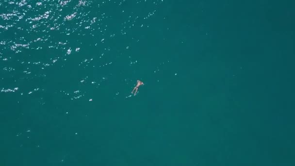 Drone view: a man swimming in the sea. A swimmer in the water. Top view of the ocean. — Stock Video