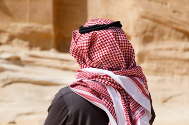 Al Ula, Suudi Arabistan, 19 Şubat 2020: Geleneksel başlıklı bir Suudi Arabistan turisti El Ula 'da bir mezarın önünde duruyor