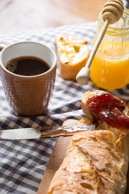 Kırsal kumaş üzerinde ev yapımı kahvaltı, bir fincan kahve, bal, reçel, taze ekmek