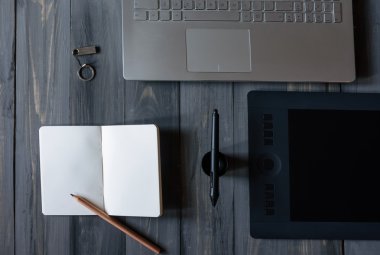 Bilgisayarlı ofis masası, tablet bilgisayar, not defteri ve kalem, karanlık ofis geçmişi.