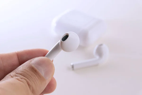 Segurando Genéricos Wireless Ear Phone Cor Branca — Fotografia de Stock