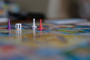 Renkli piyonlar ve bir zarla bir masa oyunu kapat