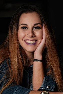 Uzun saçlı, gülümseyen güzel bir kadının portresi.