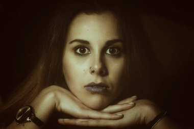 Koyu arkaplanda uzun saç portresi olan güzel esmer.