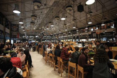 Lizbon, Portekiz - 2 Ocak 2020: Turistler ve yerliler Lizbon 'daki kapalı bir pazar yerinde dünyanın dört bir yanından gelen çeşitli yiyecek ve içeceklerin tadını çıkarıyorlar