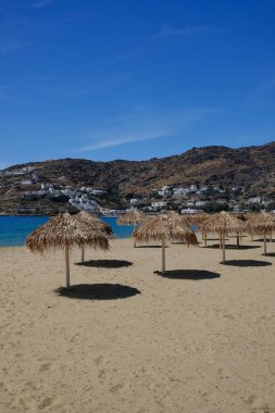 Ios siklades Yunanistan 'ın kumlu Mylopotas plajında plaj şemsiyeleri 