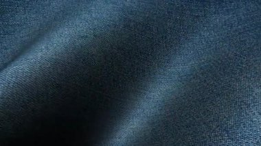 Çiğ mavi kot kumaş dalgaları doğal tekstil görselleri için uygun organik hareketlerle yer değiştiriyor.