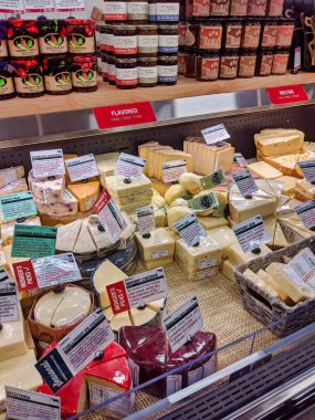 Kirkland, WA / USA - Aralık 2019: Kirkland QFC marketinin içindeki şarküteride sergilenen çeşitli peynir parçalarının görüntüsü.