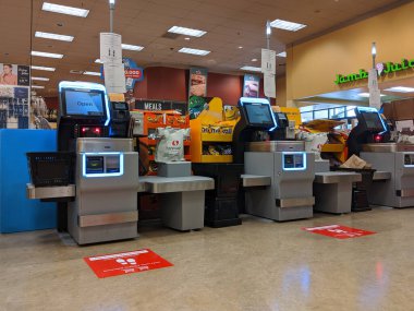 Kirkland, WA / USA - Mart 2020 civarı: Washington 'daki barınak sırasında Safeway' deki bir marketin kendi kendine kontrol çizgilerinde toplumsal uzaklık talimatı veren işaretler