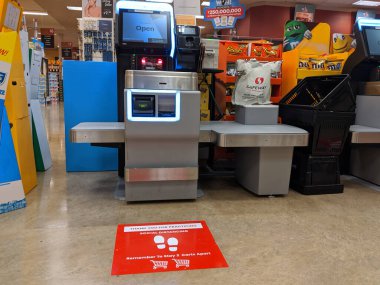 Kirkland, WA / USA - Mart 2020 civarı: Washington 'daki barınak sırasında Safeway' deki bir marketin kendi kendine kontrol çizgilerinde toplumsal uzaklık talimatı veren işaretler