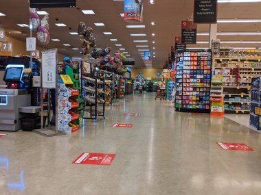 Kirkland, WA / USA - Mart 2020 civarı: Washington 'daki barınak sırasında Safeway' deki bir bakkal dükkanının çıkış çizgilerinde toplumsal uzaklık talimatı veren işaretler