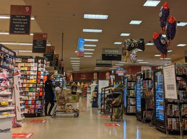 Kirkland, WA / USA - Nisan 2020: Safeway 'deki bir markette yüz maskesi takmış müşteriler, güvenlik için yere sosyal mesafe etiketleri yapıştırdılar.