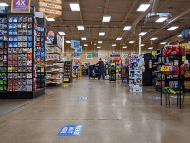 Kirkland, WA / USA - Nisan 2020: Fred Meyer 'in marketinde yüz maskesi takmış müşteriler, güvenlik için yere yapıştırılmış sosyal mesafe etiketleri ile