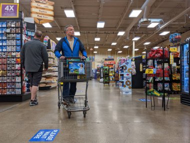 Kirkland, WA / USA - Nisan 2020: Fred Meyer 'in marketinde yüz maskesi takmış müşteriler, güvenlik için yere yapıştırılmış sosyal mesafe etiketleri ile