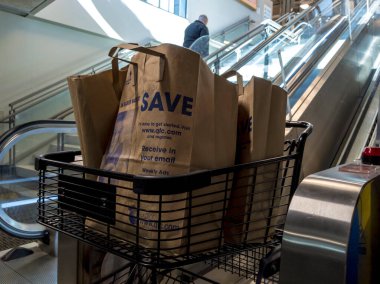 Seattle, WA / USA - Mayıs 2020: QFC marketinin içinde yürüyen merdivenden çıkan bir alışveriş arabasının görüntüsü.