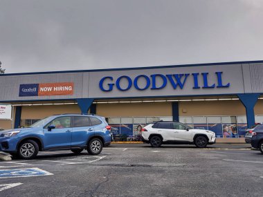 Bellevue, WA / USA - circa February 2020: Exterior view of a Goodwill Donation and Thrift Shop, cars lining up for the donation line. clipart