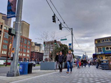 Seattle, WA / USA - Kasım 2019: Seattle şehir merkezindeki University Street açıklarında Elliott Körfezi boyunca yürüyen insanlar,