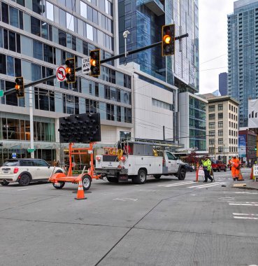 Seattle, WA / USA - Kasım 2019: Stewart Caddesi 'nde inşaat devam ediyor, güvenlik için arabaları işçilerden uzaklaştıran bir trafik denetçisi.