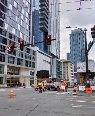 Seattle, WA / USA - Kasım 2019: Stewart Caddesi 'nde inşaat devam ediyor, güvenlik için arabaları işçilerden uzaklaştıran bir trafik denetçisi.