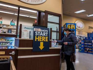 Kirkland, WA USA - Mart 2021: Safeway eczanesinde sıra bekleyen kadın, Covid 19 aşısı vurulmasını bekliyor.