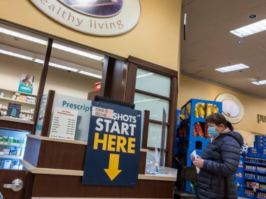 Kirkland, WA USA - Mart 2021: Safeway eczanesinde sıra bekleyen kadın, Covid 19 aşısı vurulmasını bekliyor.