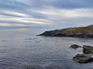 San Juan Adası kayalık sahilinin nefes kesici manzarası. Limanın üzerinde yuvarlanan, bulutlu bulutlar.