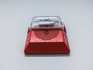 Plastik acil durum alarm kutusunun yakın görüntüsü bir iş yerindeki duvara bağlı.