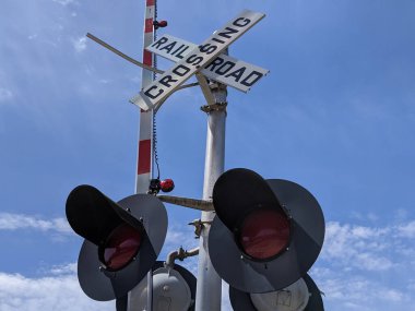 Sakin küçük bir kasabada, bir tren yolu kavşağındaki trafik ışıklarının alçak açılı görüntüsü