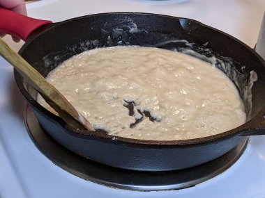 Fırının tepesindeki dökme demir tavada un ve tereyağından allık yapma süreci.