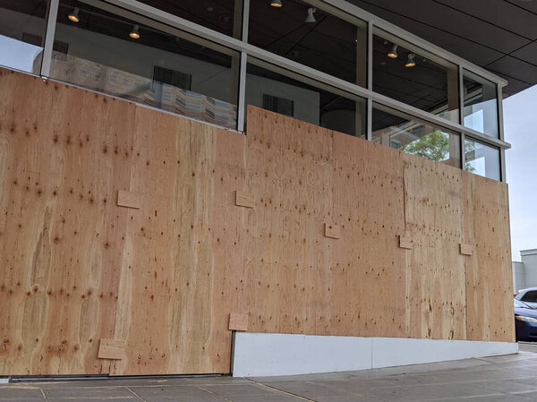 Вид заколоченных окон и дверей в центре города во время протестов и беспорядков среди Ковид-19