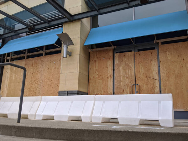 Вид заколоченных окон и дверей в центре города во время протестов и беспорядков среди Ковид-19